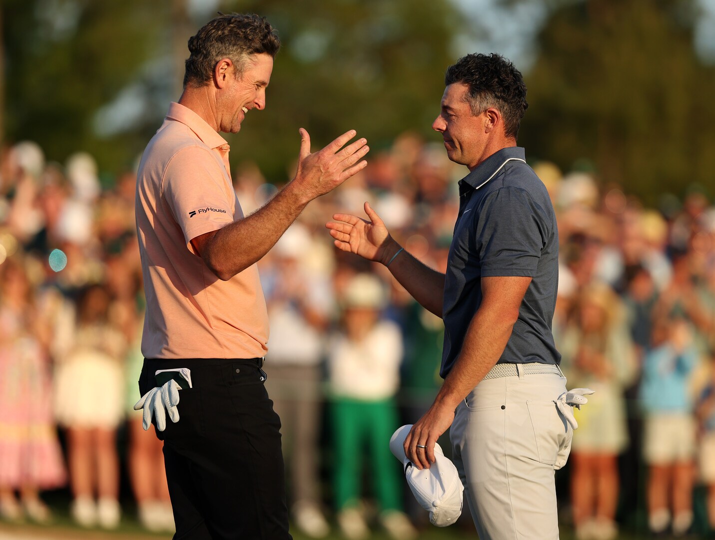 Rory McIlroy and Justin Rose shaking hands after a playoff hole at the Masters Tournament.