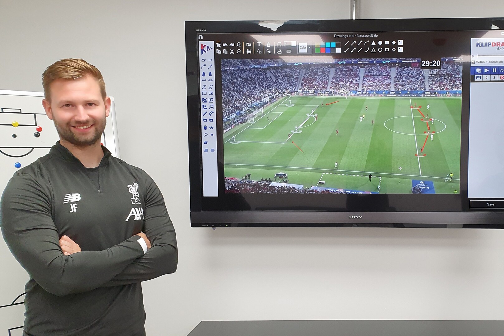 Photo of James French, former Liverpool set-piece coach, now with Man City, standing in front of a TV screen showing a soccer game analysis.