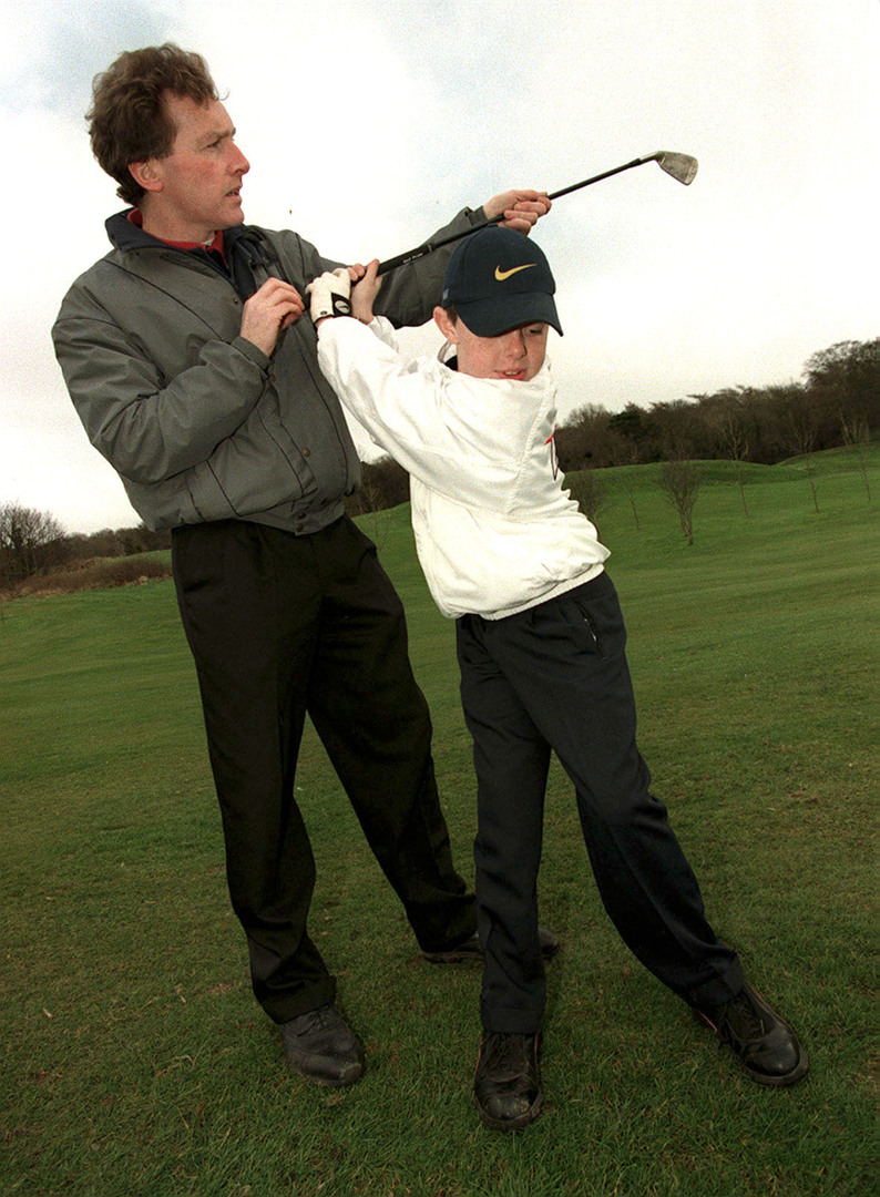 Young Rory McIlroy training with his coach.